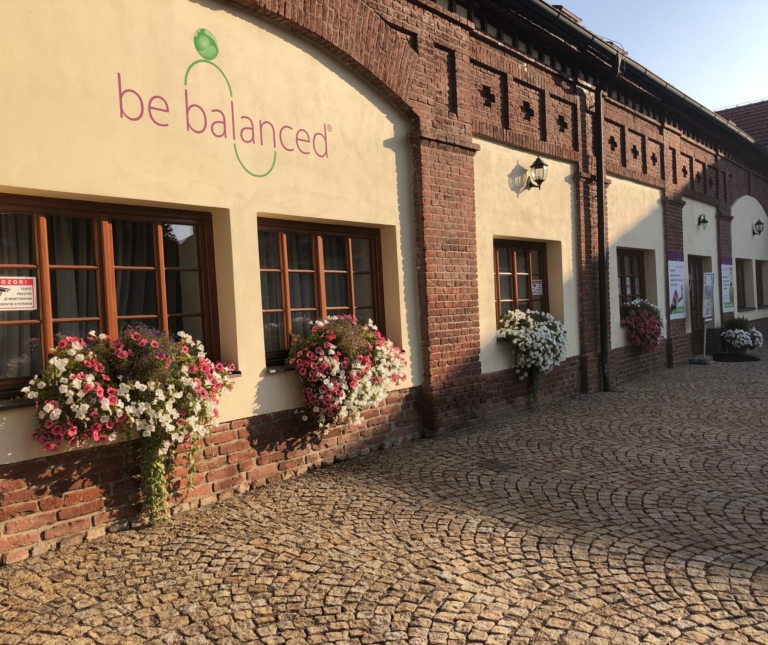 Vstup do centra Be Balanced v Praze 6 — cihlová budova s květinami